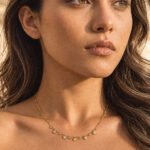 Woman wearing Aurevia Necklace, a delicate gold necklace with polished golden spheres and subtle crystal accents