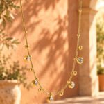 Aurevia Necklace displayed on an elegant background with polished golden spheres and subtle crystal accents