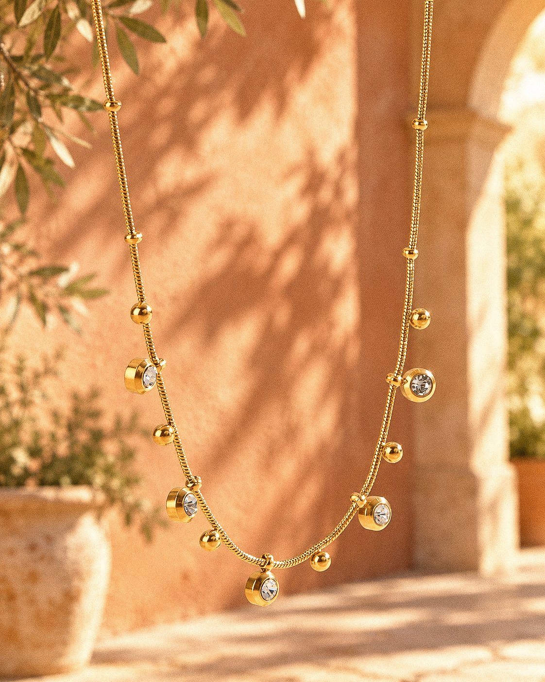 Aurevia Necklace displayed on an elegant background with polished golden spheres and subtle crystal accents