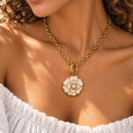 Woman wearing Avelora Necklace by Calvéra, a dual-tone statement necklace with polished golden rings and engraved silver-toned details