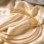 Collare Aureo Choker on background in angled view showing layered gold collar structure