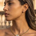 Close-up of Eterna Eleganza Necklace on model showing polished gold finish