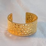 A luxurious 'Golden Weave' Cuff bracelet, merging high-end elegance with durable, water-resistant 18K PVD gold.