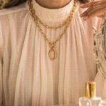 Valdora Necklace wrapped twice on model with a bold layered gold look