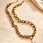 Valeria Necklace flat lay with sculptural gold chain design and pearl-inspired pendant
