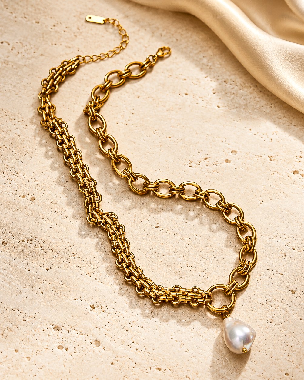 Valeria Necklace flat lay with sculptural gold chain design and pearl-inspired pendant