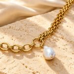 Valeria Necklace on marble background with mixed gold chain and pearl-inspired pendant
