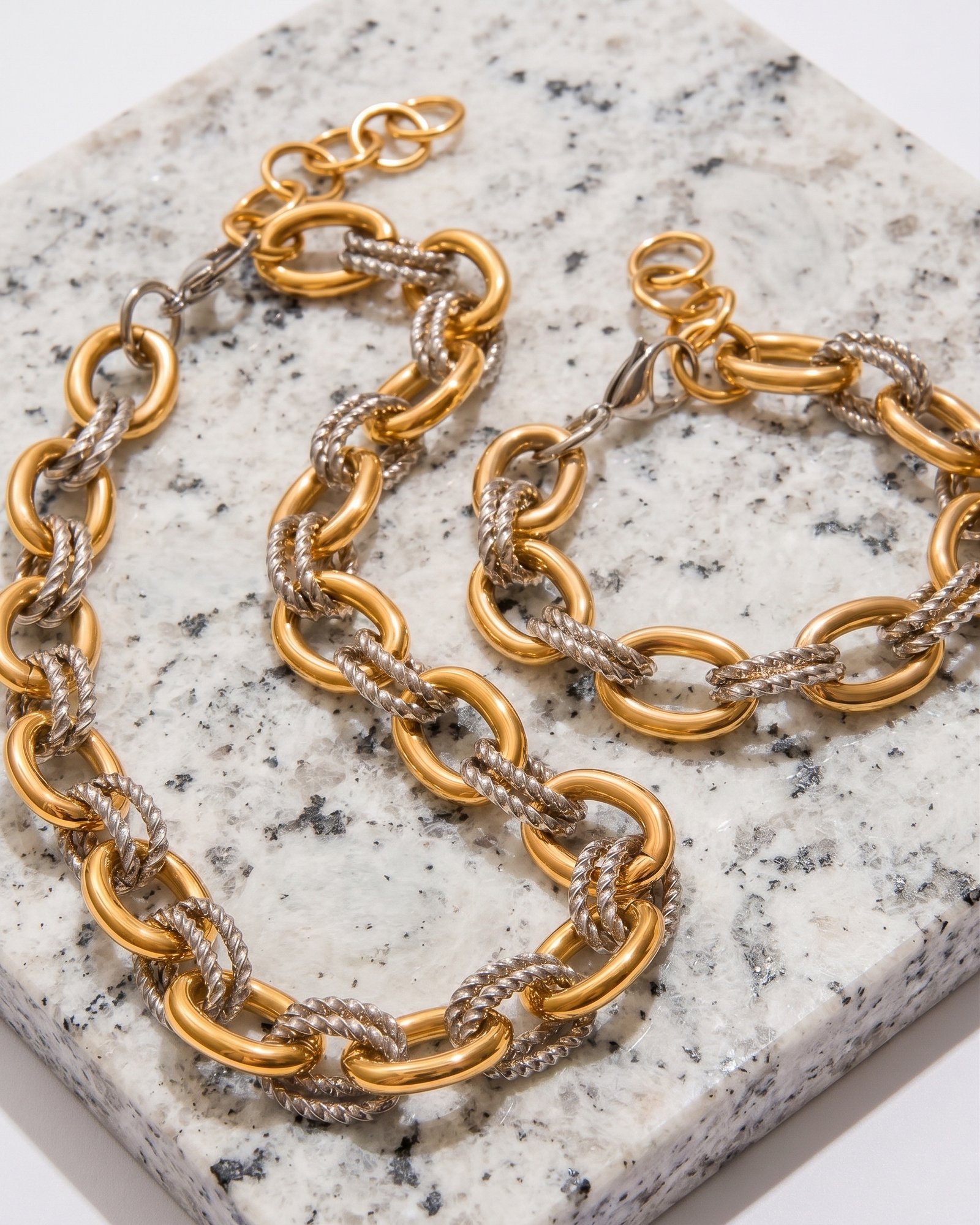 Flat lay of Regia Trama Collection on marble background showing necklace and bracelet set