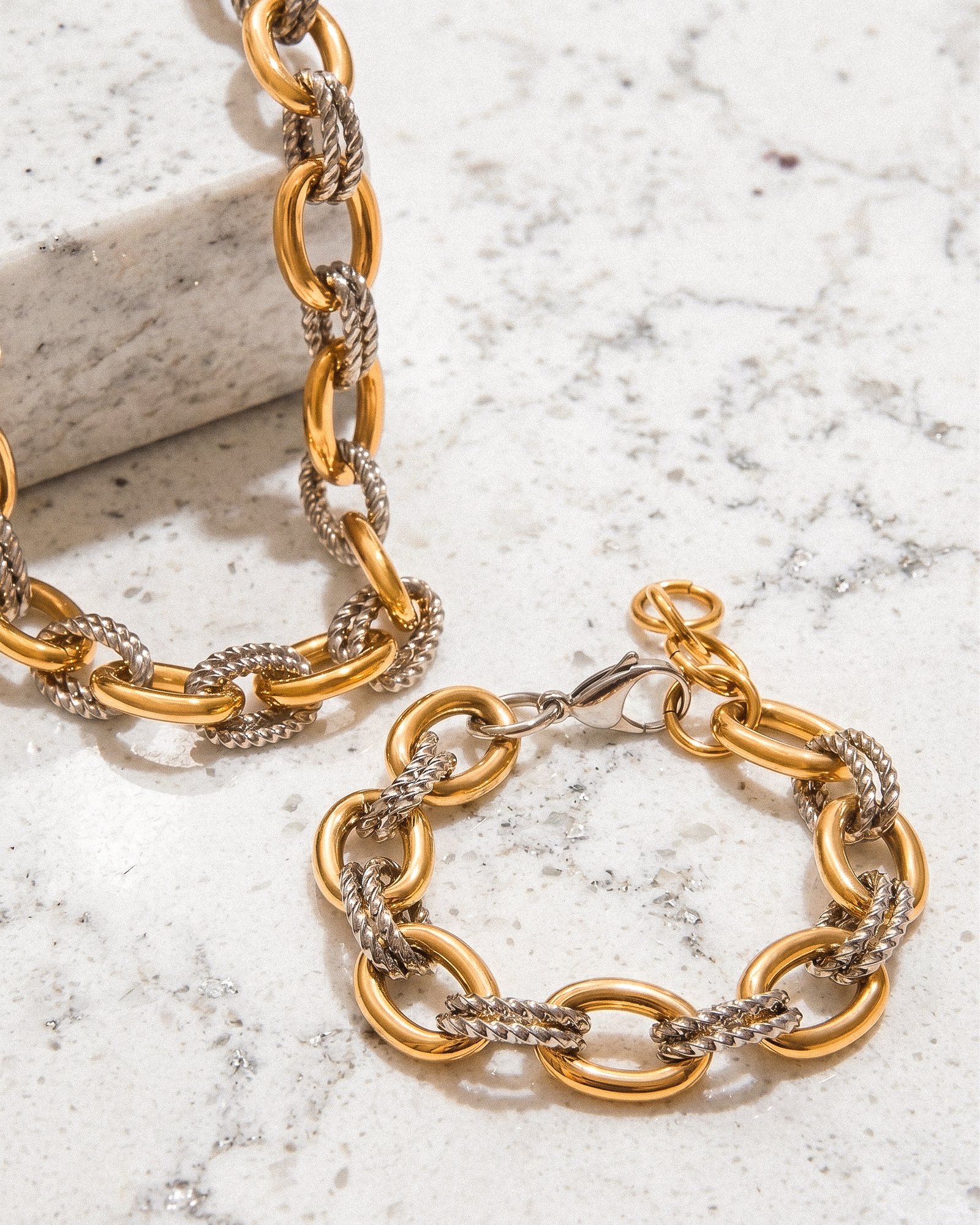 Elegant Regia Trama Collection display on marble background with coordinated necklace and bracelet