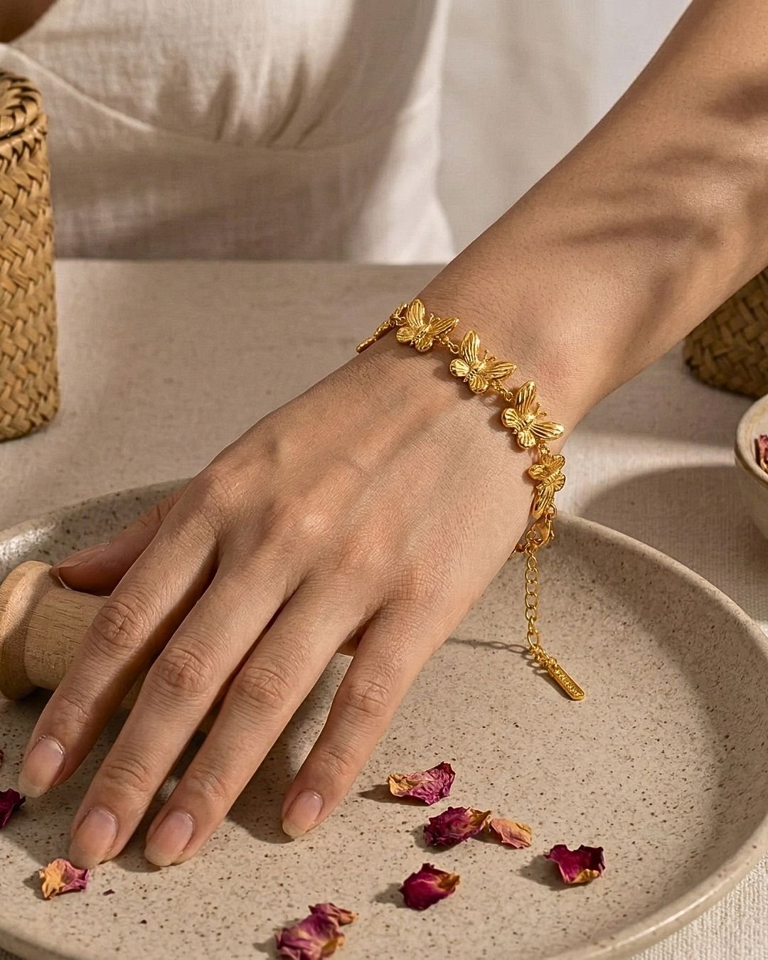 Farfalla Aurea Bracelet worn on wrist with rose petals styling