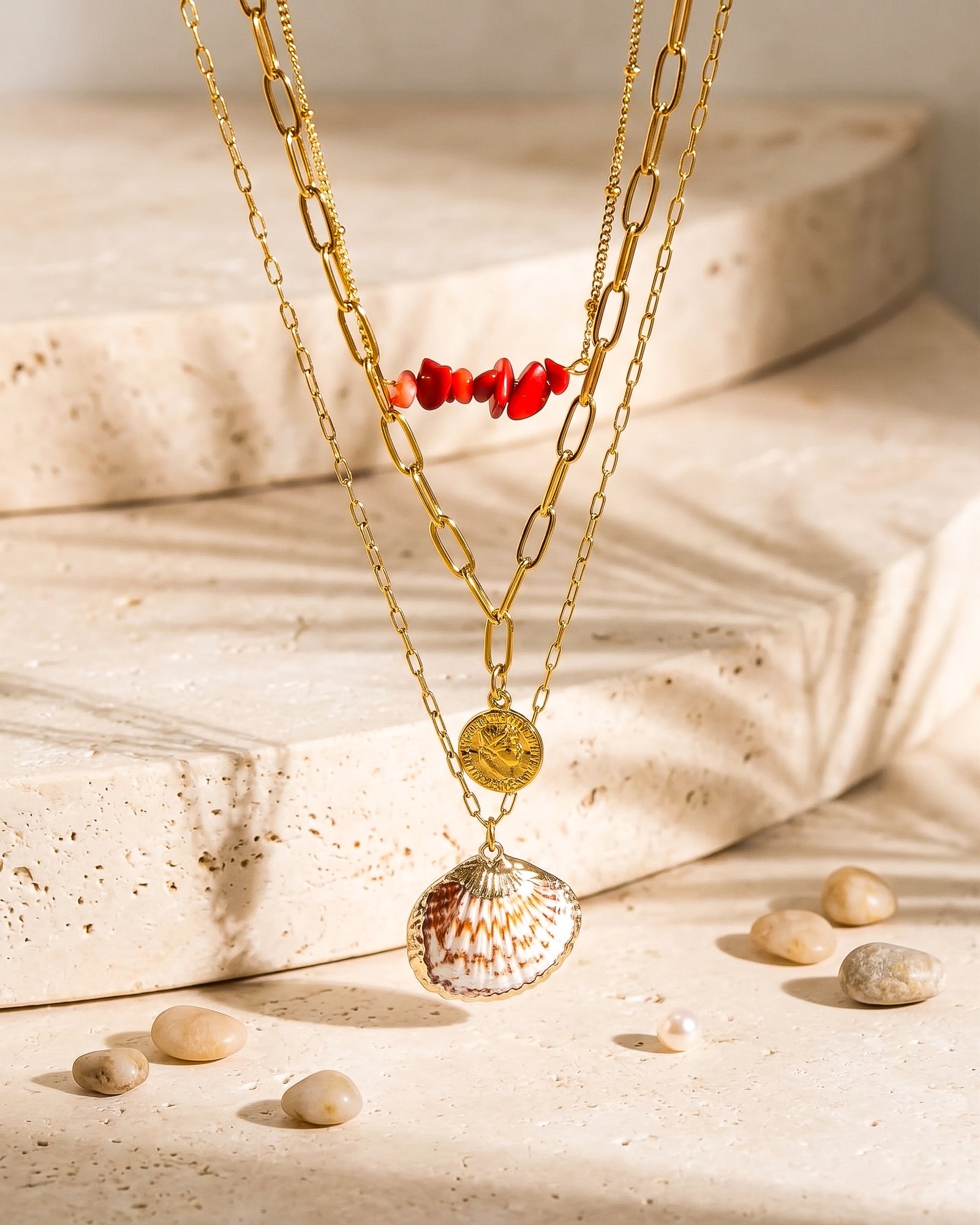 Close-up product image of Seravelle Necklace showing red beads, paperclip links, coin charm, and shell detail