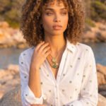 Side view of model wearing Veralia Duo Necklace with layered green bead and gold charm design