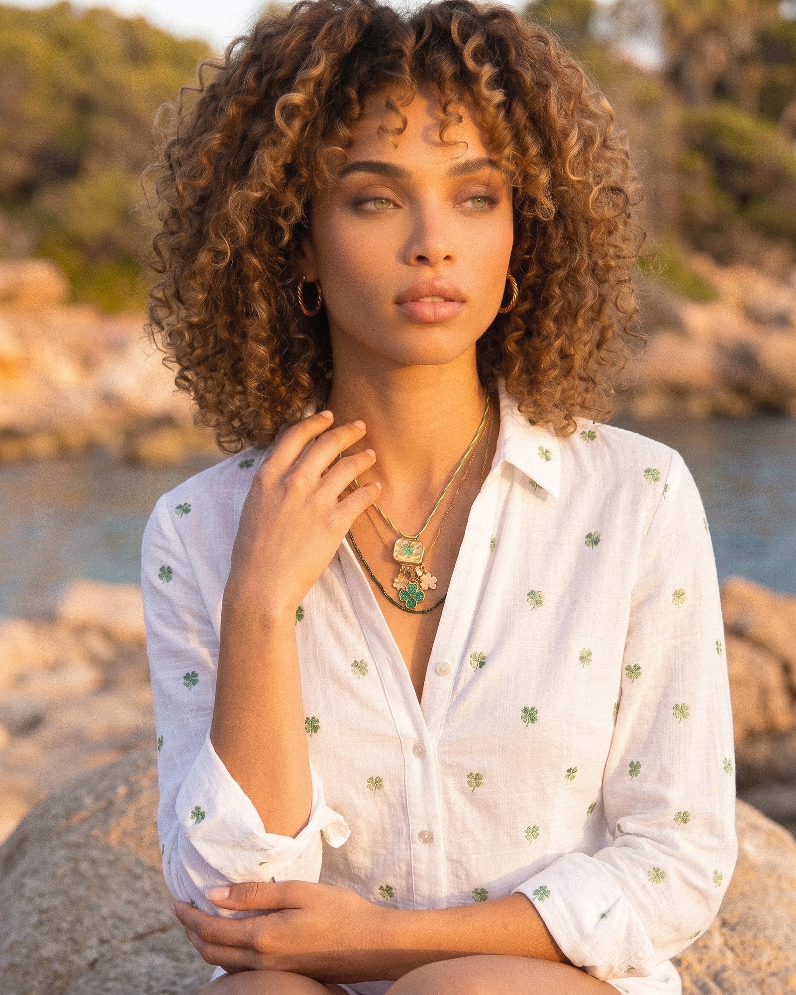 Side view of model wearing Veralia Duo Necklace with layered green bead and gold charm design