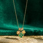 Close-up of Veralia Duo Necklace gold pendant with green clover and green bead details