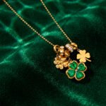 Veralia Duo Necklace displayed on luxury background with green and gold layered clover design