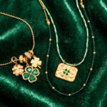 Close-up of Veralia Duo Necklace showing green crystal clover and polished golden charms