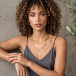 Elvara Necklace on model angled view with layered gold chains
