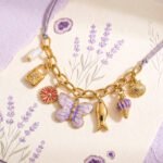 Detailed view of Lunella Charm Necklace clasp and chain section on a neutral background