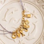Lunella Charm Necklace arranged on an elegant textured background with full charm visibility