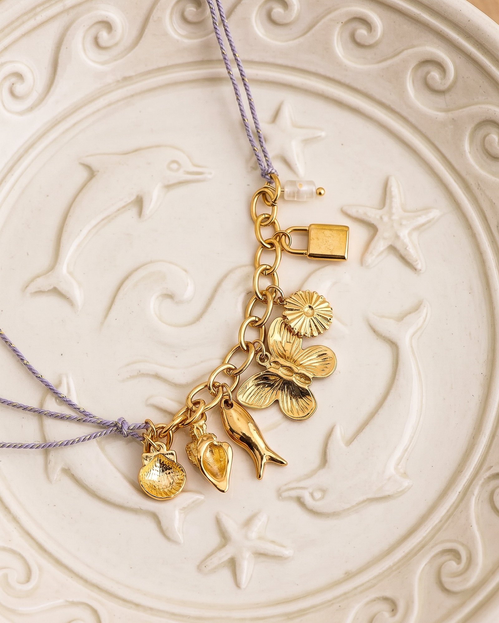 Lunella Charm Necklace arranged on an elegant textured background with full charm visibility