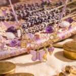 Close-up product image of Lunella Charm Necklace charms including butterfly, shell, moon, and floral details