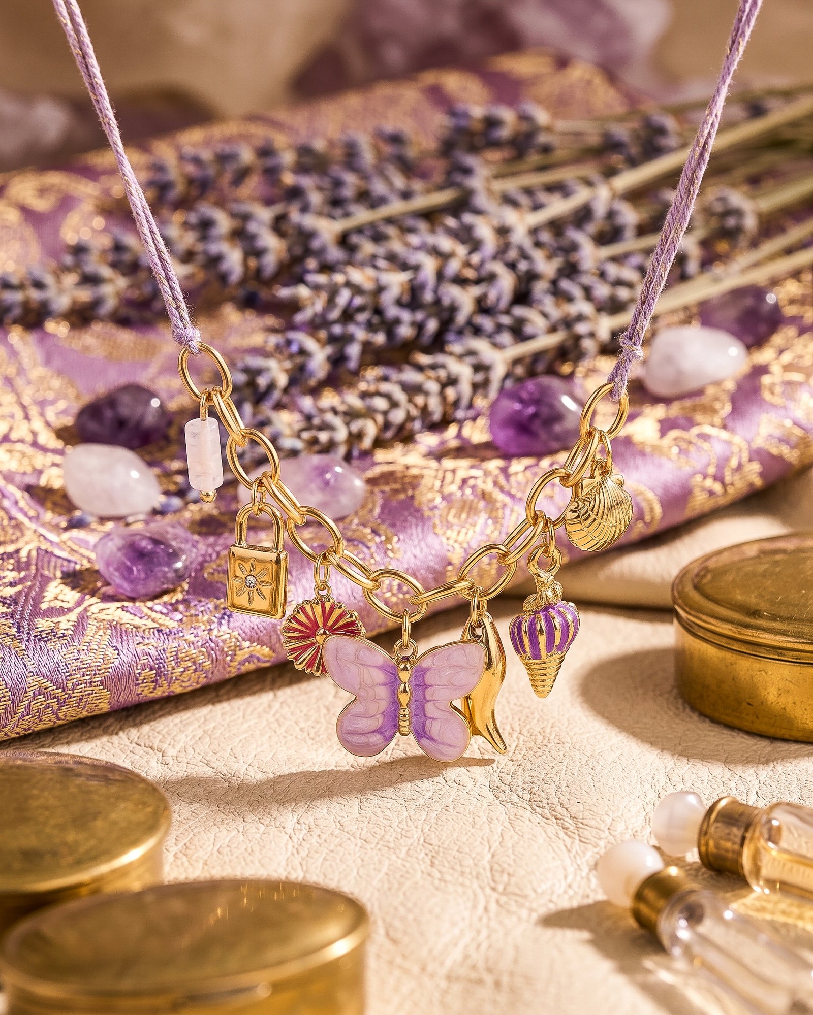 Close-up product image of Lunella Charm Necklace charms including butterfly, shell, moon, and floral details