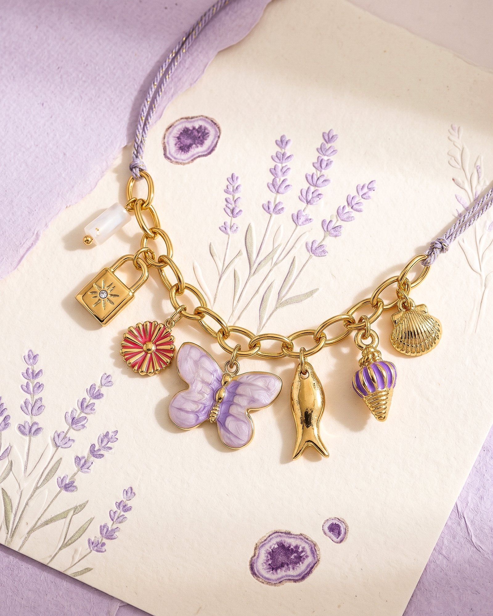 Detailed view of Lunella Charm Necklace clasp and chain section on a neutral background