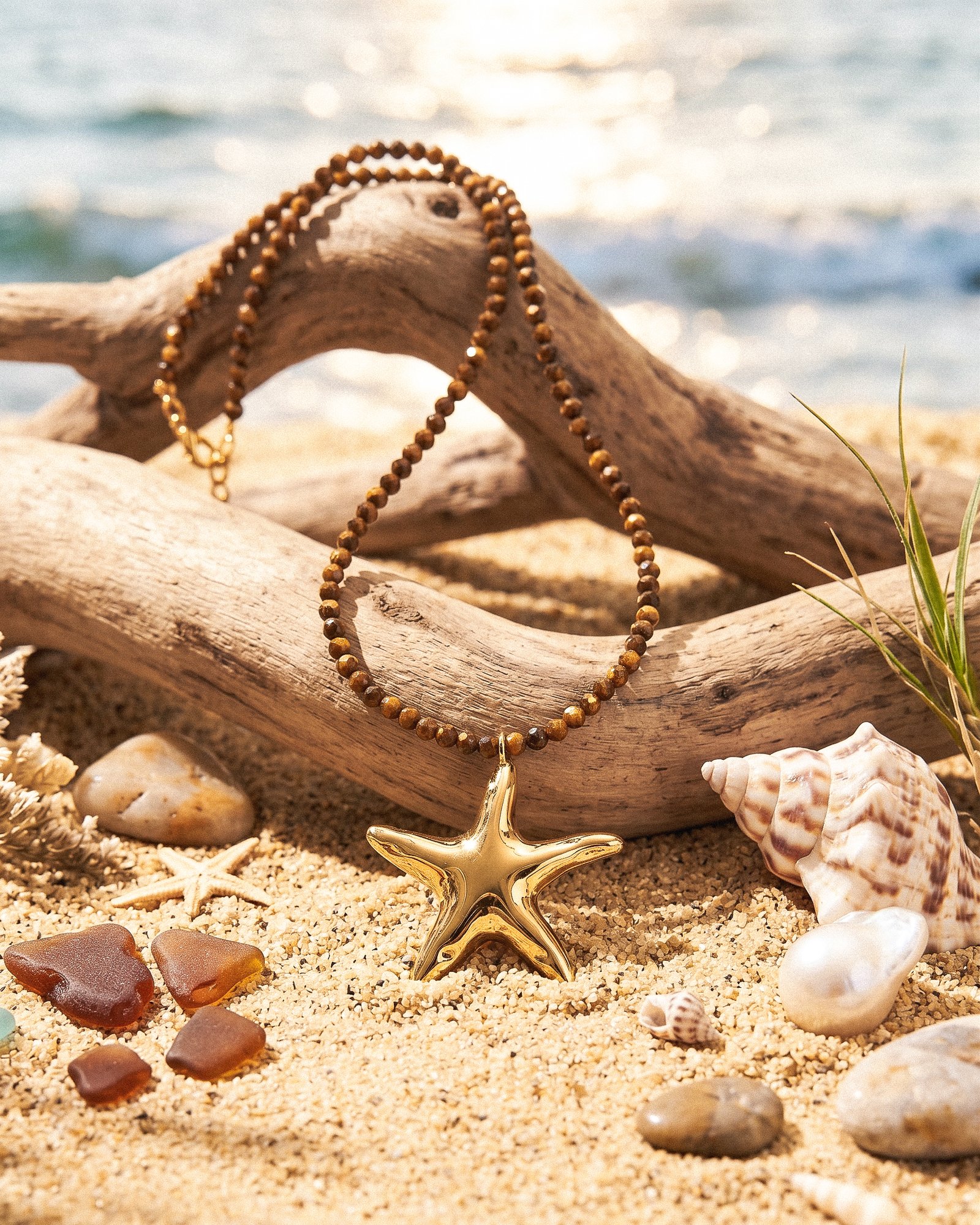 Stella Terra necklace from Mare Amuleti Necklaces on background with brown beads and gold starfish charm