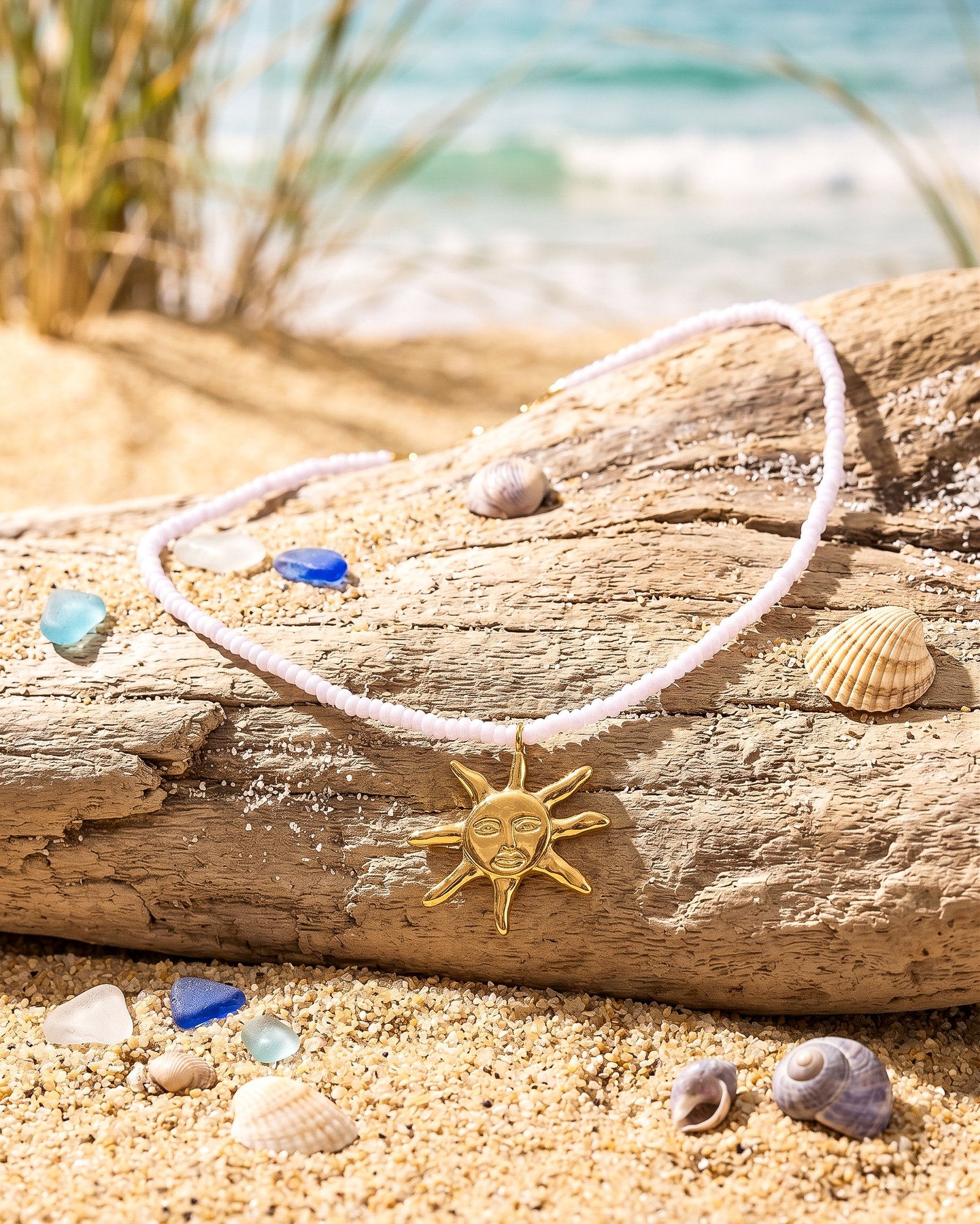 Sole Bianco necklace from Mare Amuleti Necklaces on background with white beads and gold sun charm