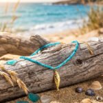 Pesce Azzurro necklace from Mare Amuleti Necklaces on background with turquoise beads and gold fish charm