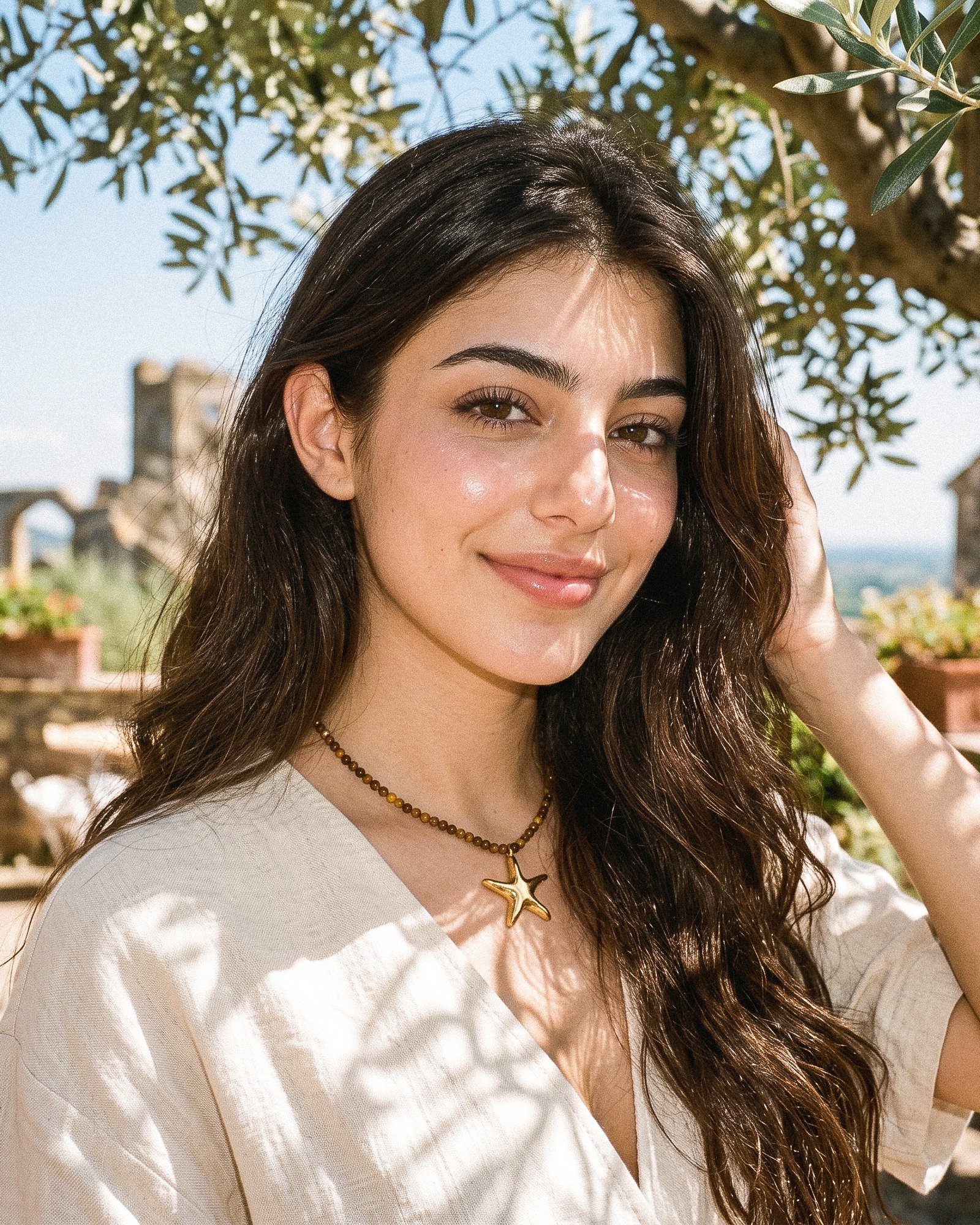 Model wearing Stella Terra from Mare Amuleti Necklaces with brown beads and gold starfish charm
