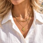 Valessia Necklace close-up on model showing the layered gold chains and coin pendant
