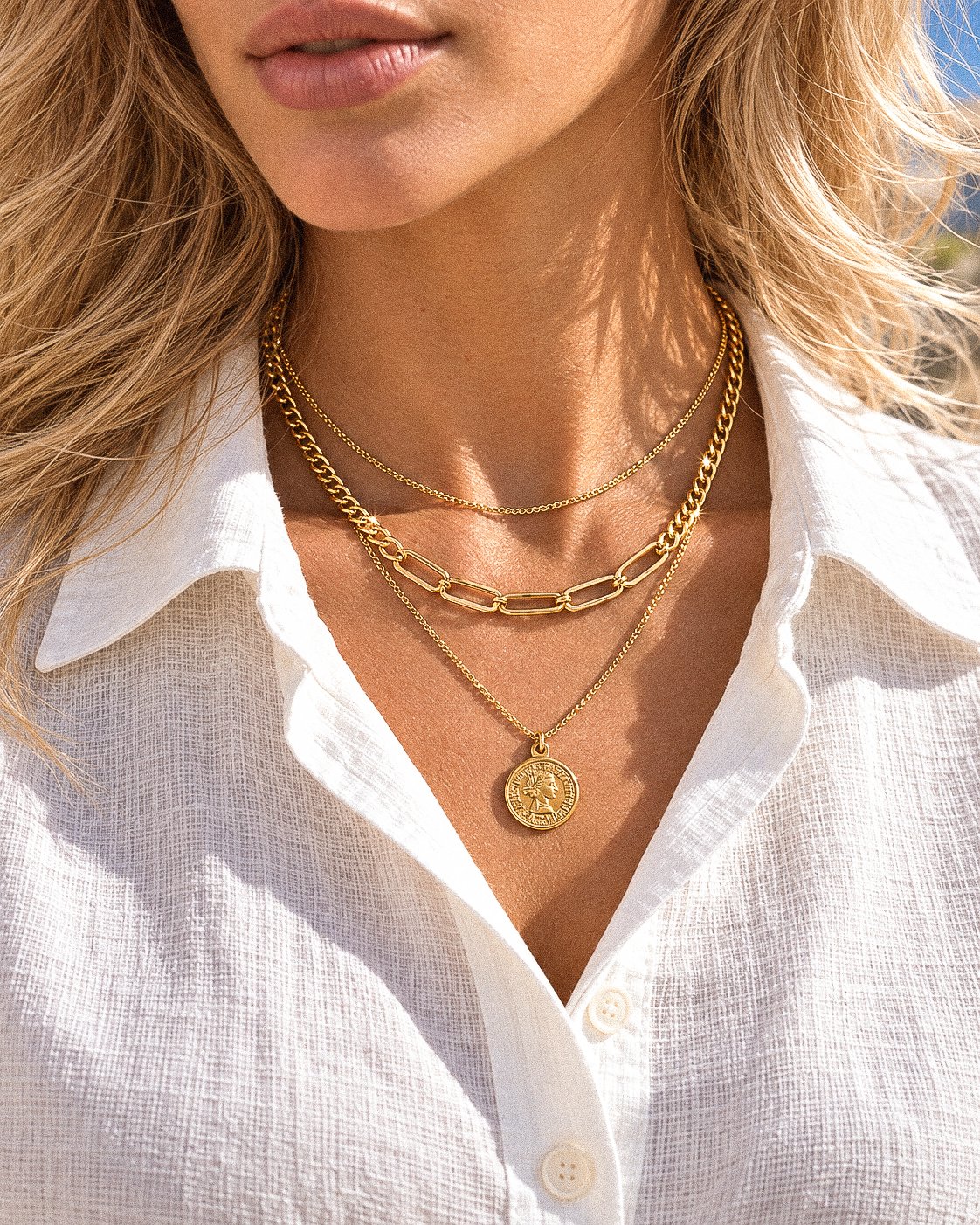 Valessia Necklace close-up on model showing the layered gold chains and coin pendant
