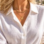 Valessia Necklace detailed close-up on model with layered gold necklace styling