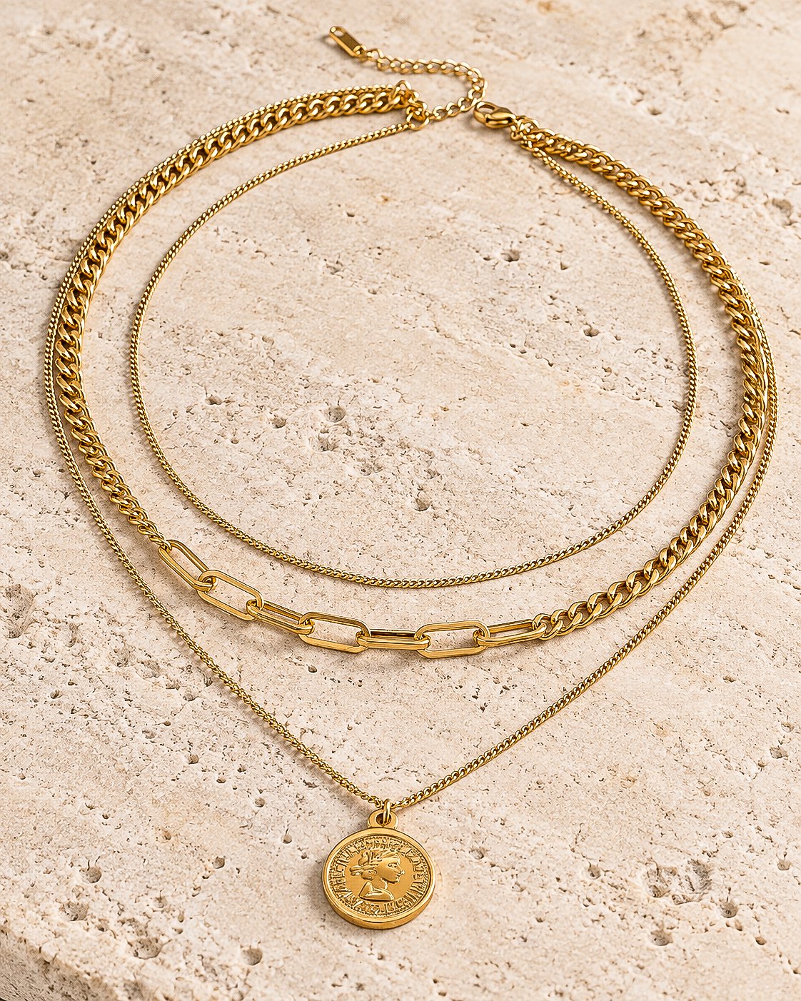 Valessia Necklace displayed on a stone background showing the layered gold chain design
