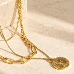 Valessia Necklace detailed product image on stone background showing the coin charm
