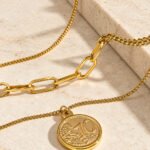 Valessia Necklace elegant display on stone background with layered gold chain styling
