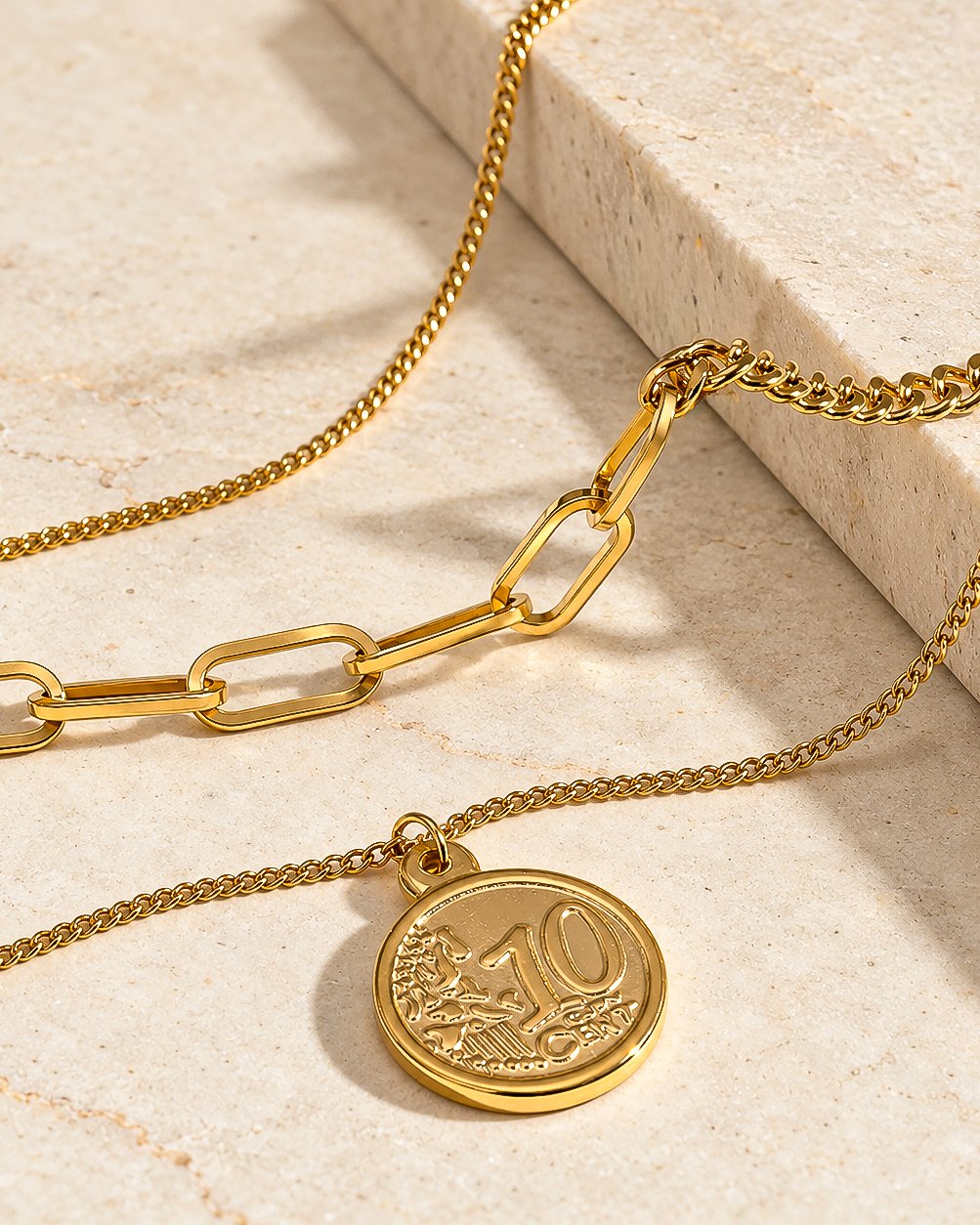 Valessia Necklace elegant display on stone background with layered gold chain styling